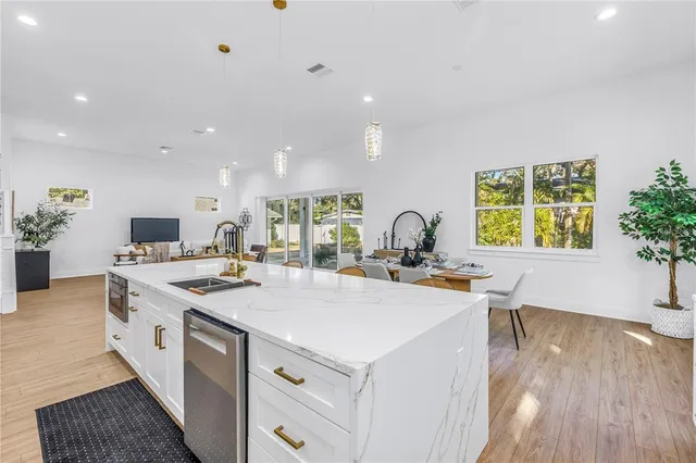 a kitchen with a stove a sink a microwave a dining table and chairs