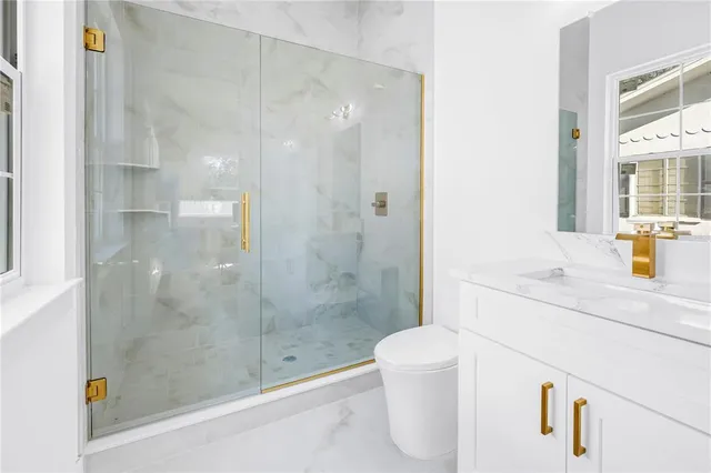 a bathroom with a sink a toilet and shower