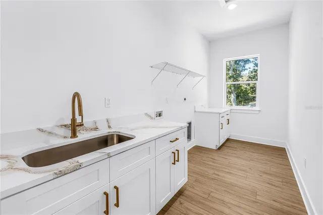 a kitchen with a sink and wooden floor