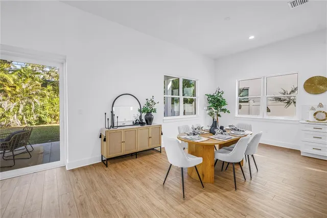 a dining room with furniture window and wooden floor