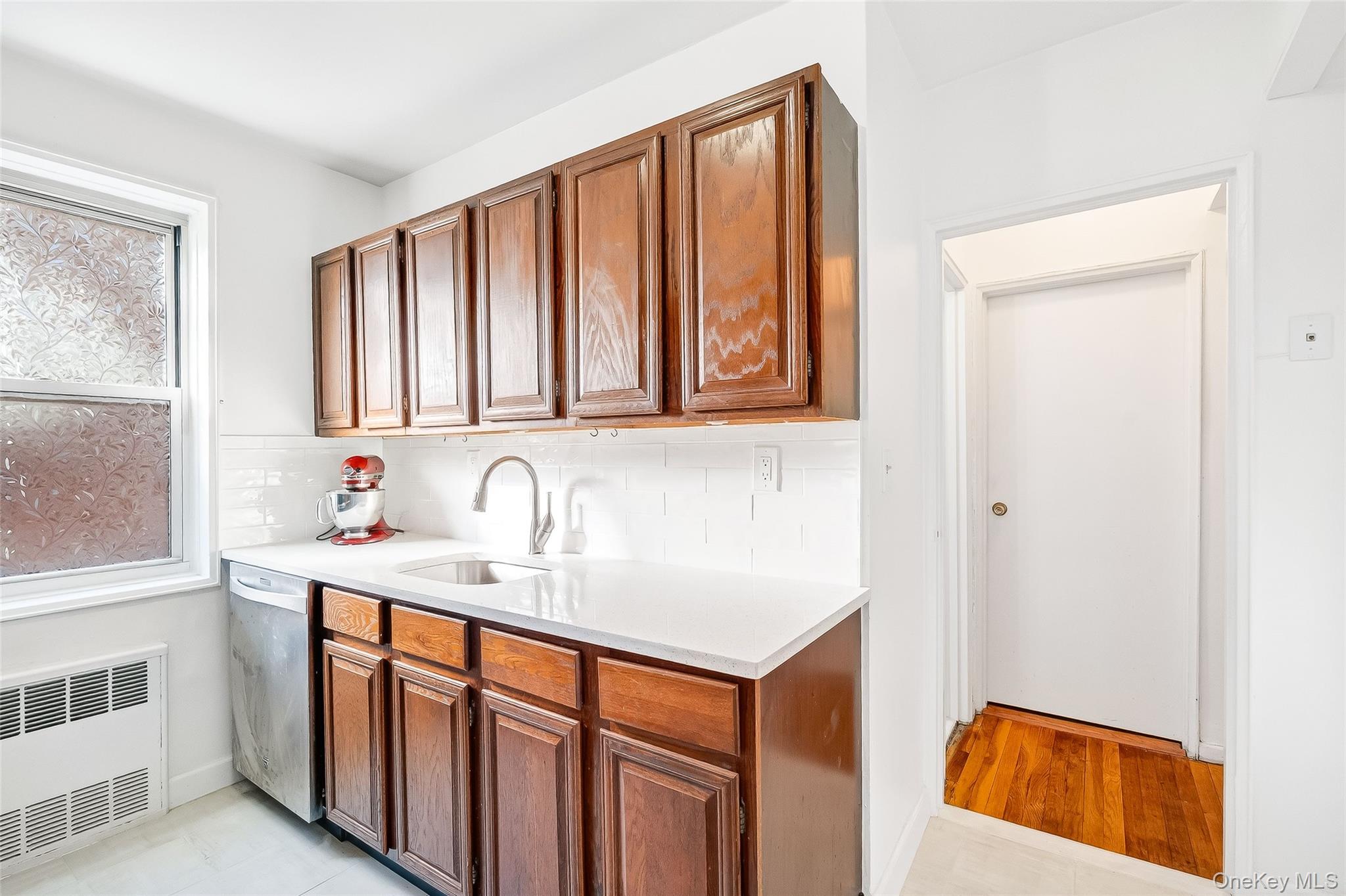 609 Palmer Road, Unit 5L Yonkers, NY 10701 - Photo 11 of 35 Kitchen with stainless steel appliances, tiled floor, quartz countertop and subway tile backsplash.