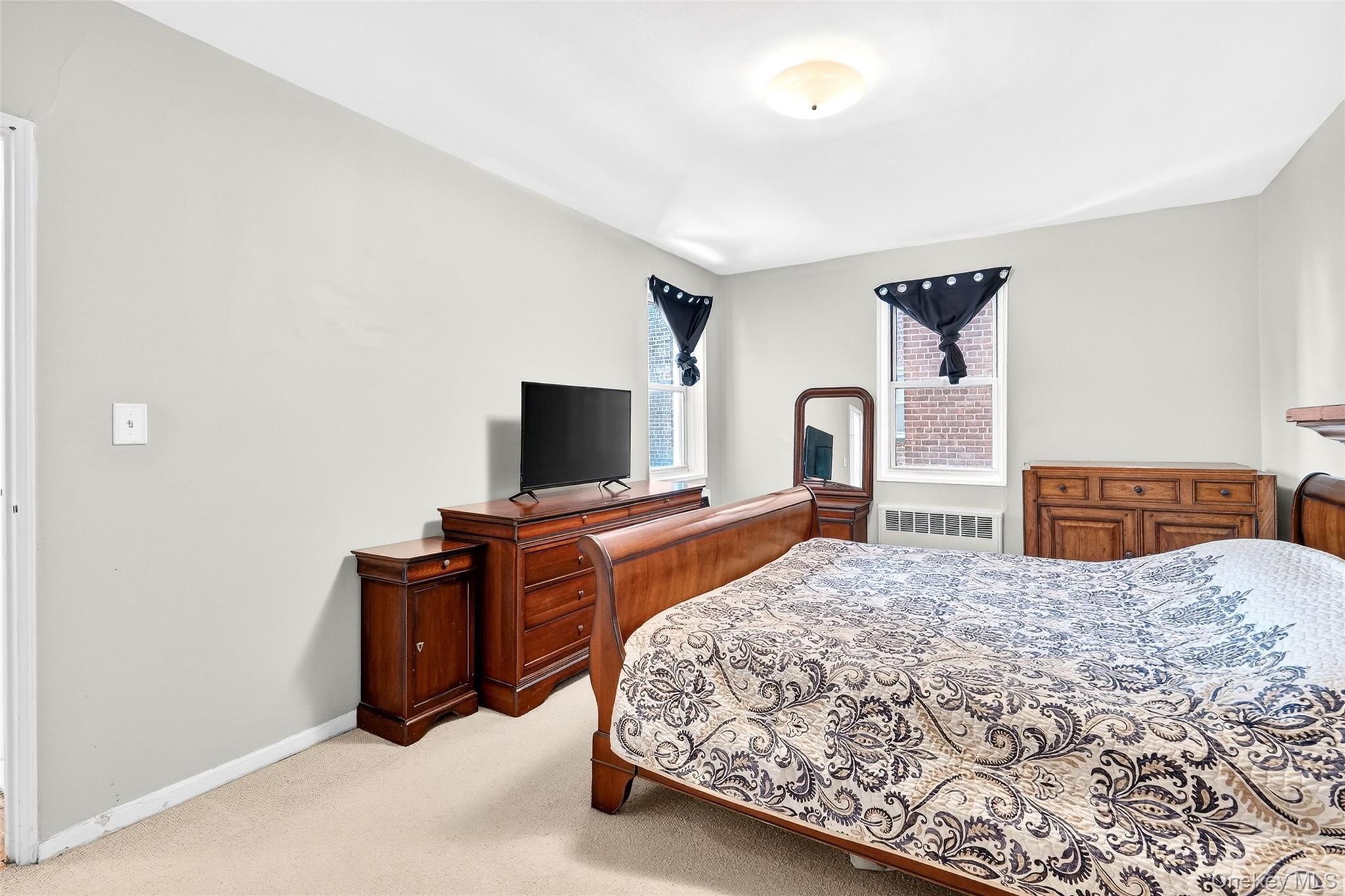 609 Palmer Road, Unit 5L Yonkers, NY 10701 - Photo 23 of 33 a bedroom with a bed and a flat screen tv
