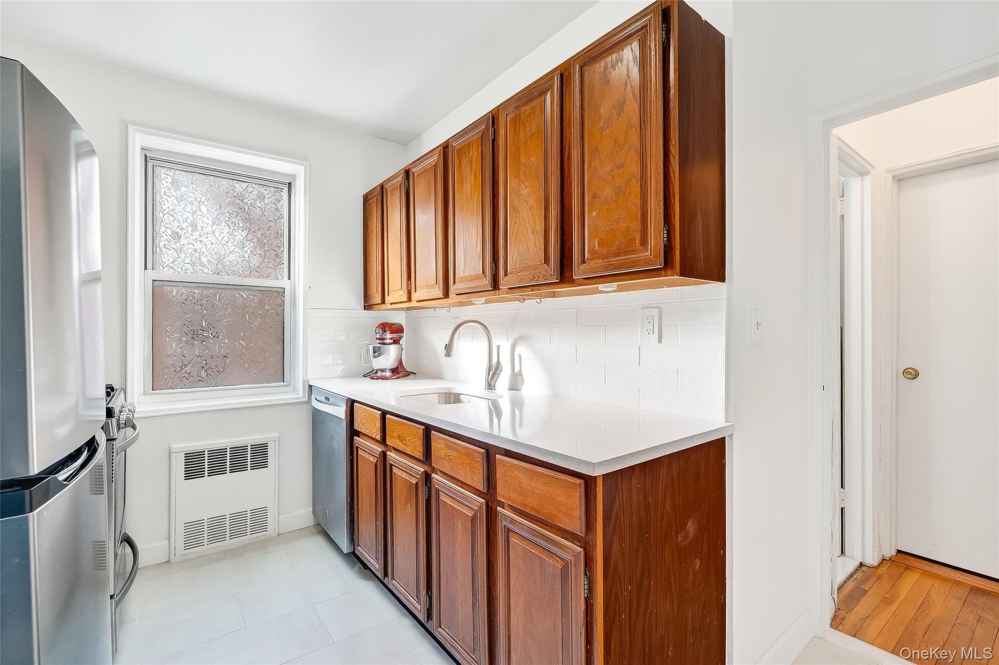 609 Palmer Road, Unit 5L Yonkers, NY 10701 - Photo 8 of 35 Kitchen with stainless steel appliances, tiled floor, quartz countertop and subway tile backsplash.