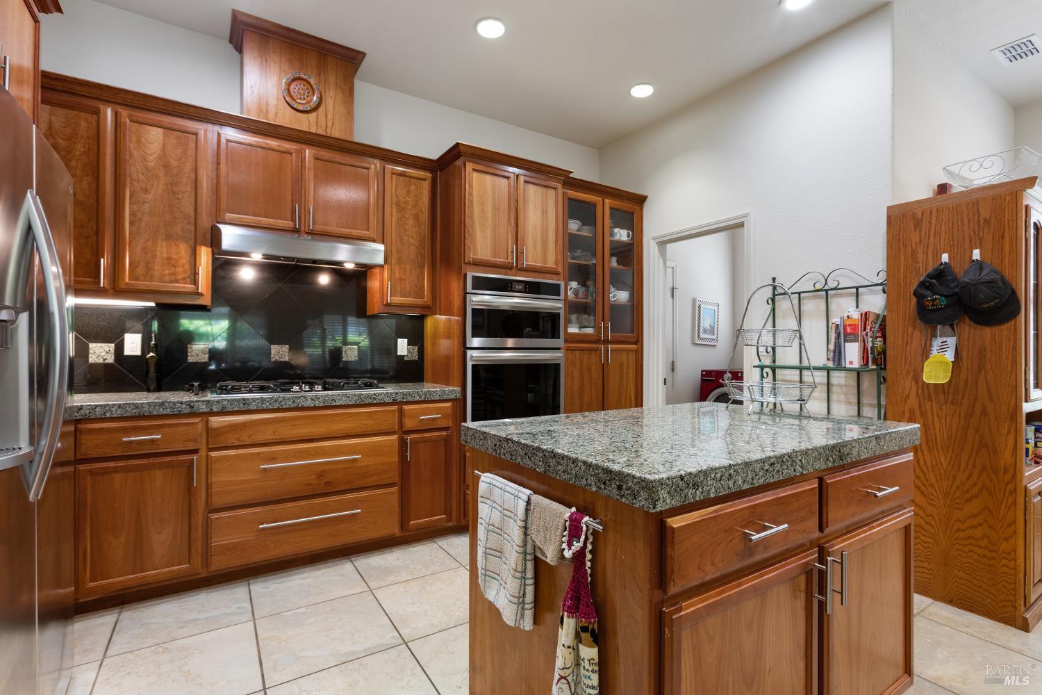 900 Livingston Place Rio Vista, CA 94571 - Photo 17 of 38 a kitchen with stainless steel appliances granite countertop a sink dishwasher and a refrigerator with wooden cabinets