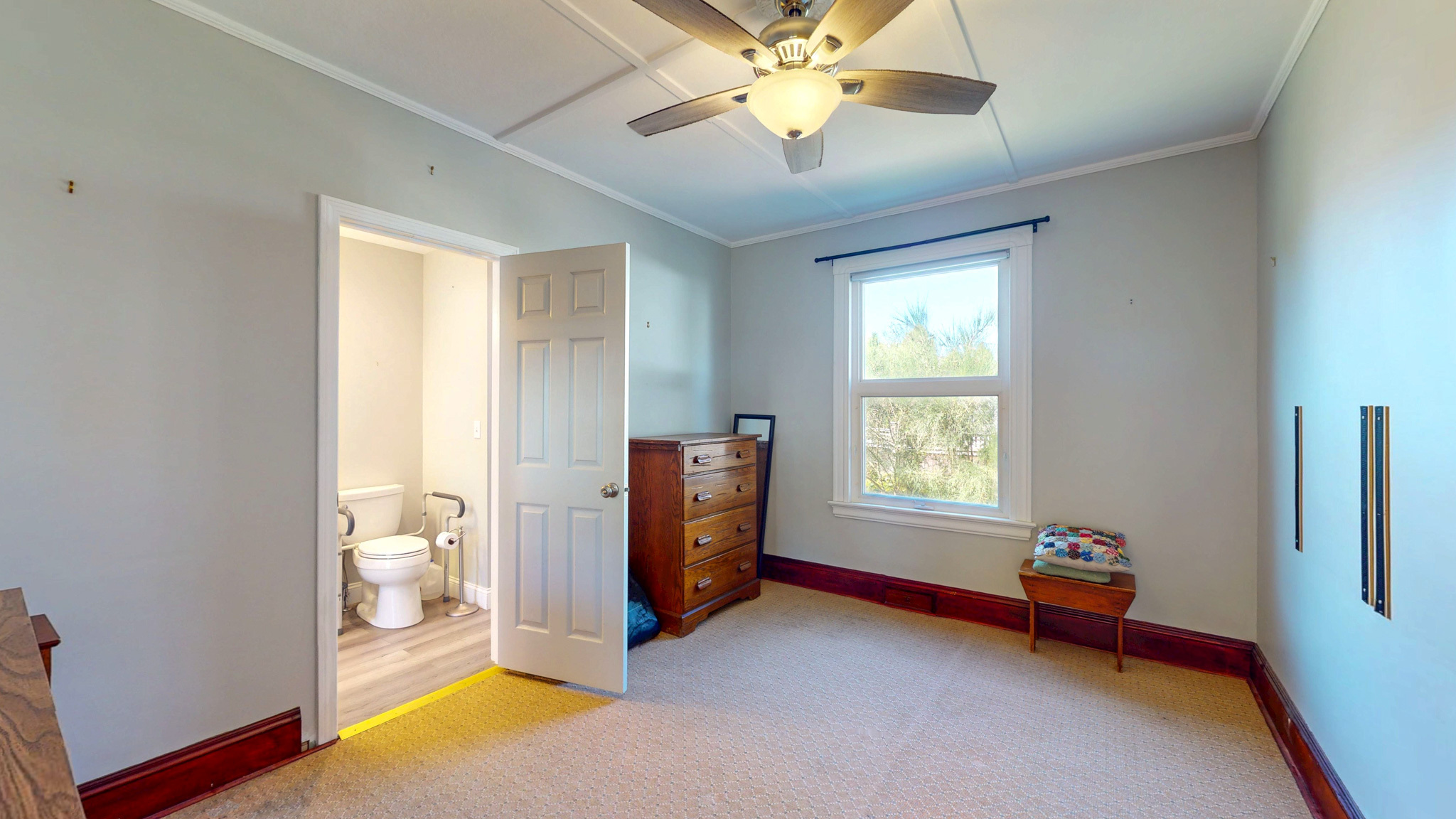 a view of an empty room with window and chandelier fan