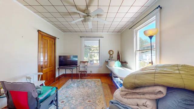 a living room with furniture a flat screen tv and a large window