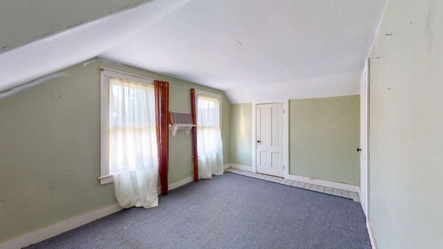 an empty room with closet and a hallway