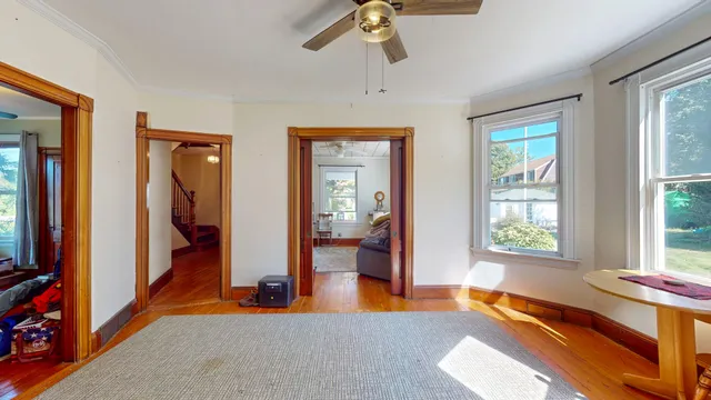 a view of an empty room with wooden floor and windows