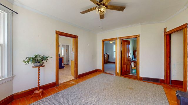 a view of a livingroom with a potted plant and wooden floor