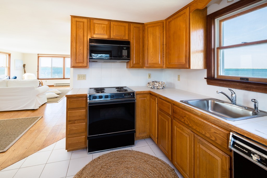 87 Salten Point Road Barnstable, MA 02630 - Photo 14 of 27 a kitchen with stainless steel appliances granite countertop a stove a sink and a microwave