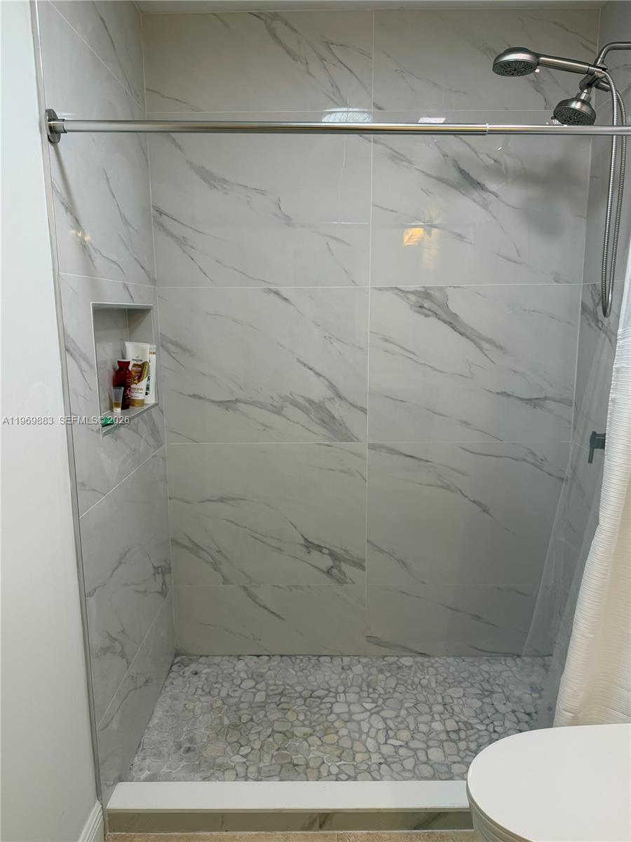 15641 Southwest 147th Avenue Miami, FL 33187 - Photo 13 of 20 a bathroom with a shower and toilet
