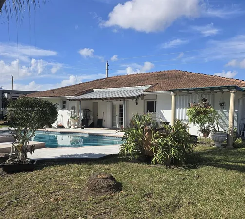 a view of a house with swimming pool and sitting area