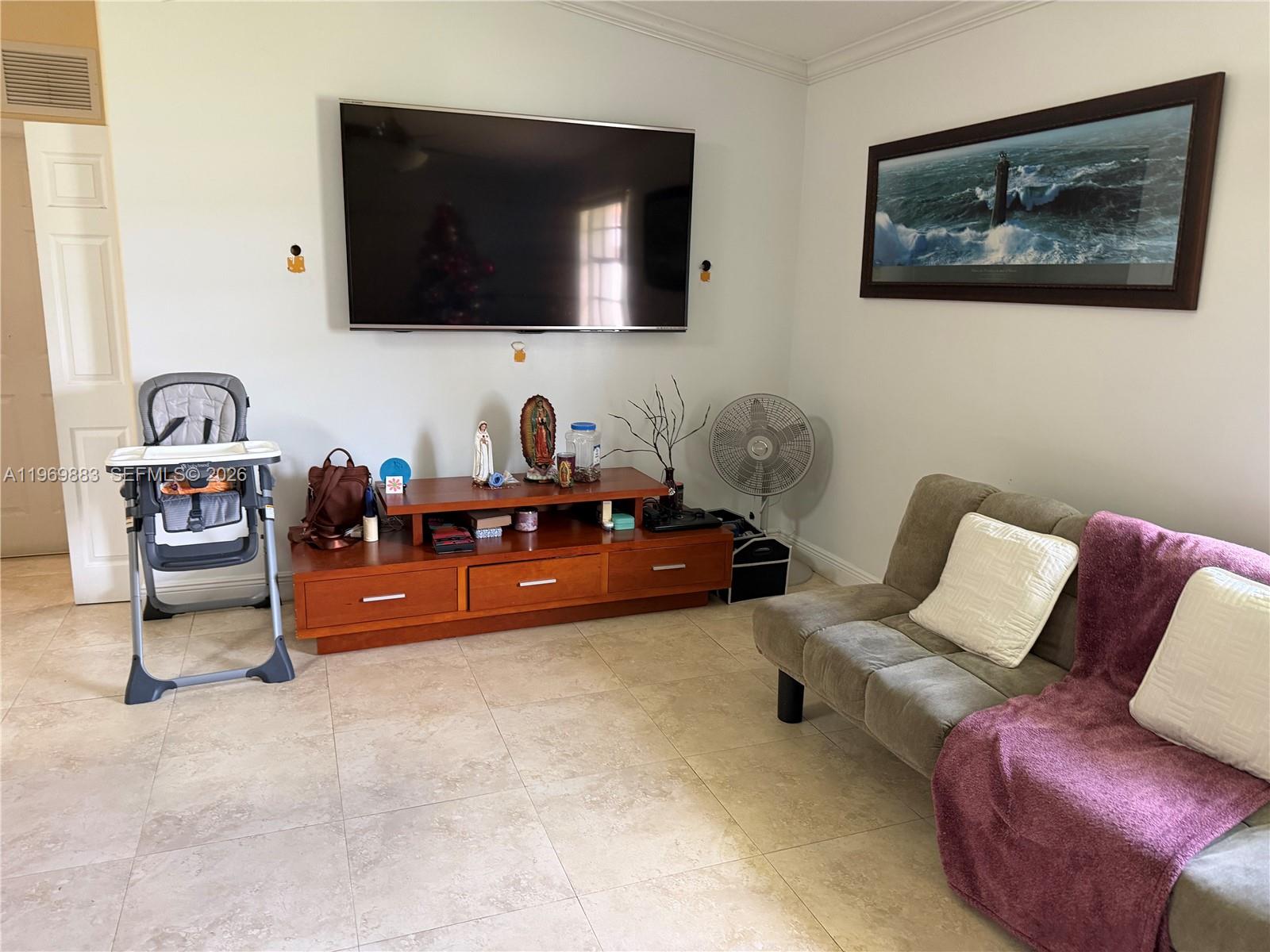 15641 Southwest 147th Avenue Miami, FL 33187 - Photo 7 of 20 a living room with furniture and a flat screen tv