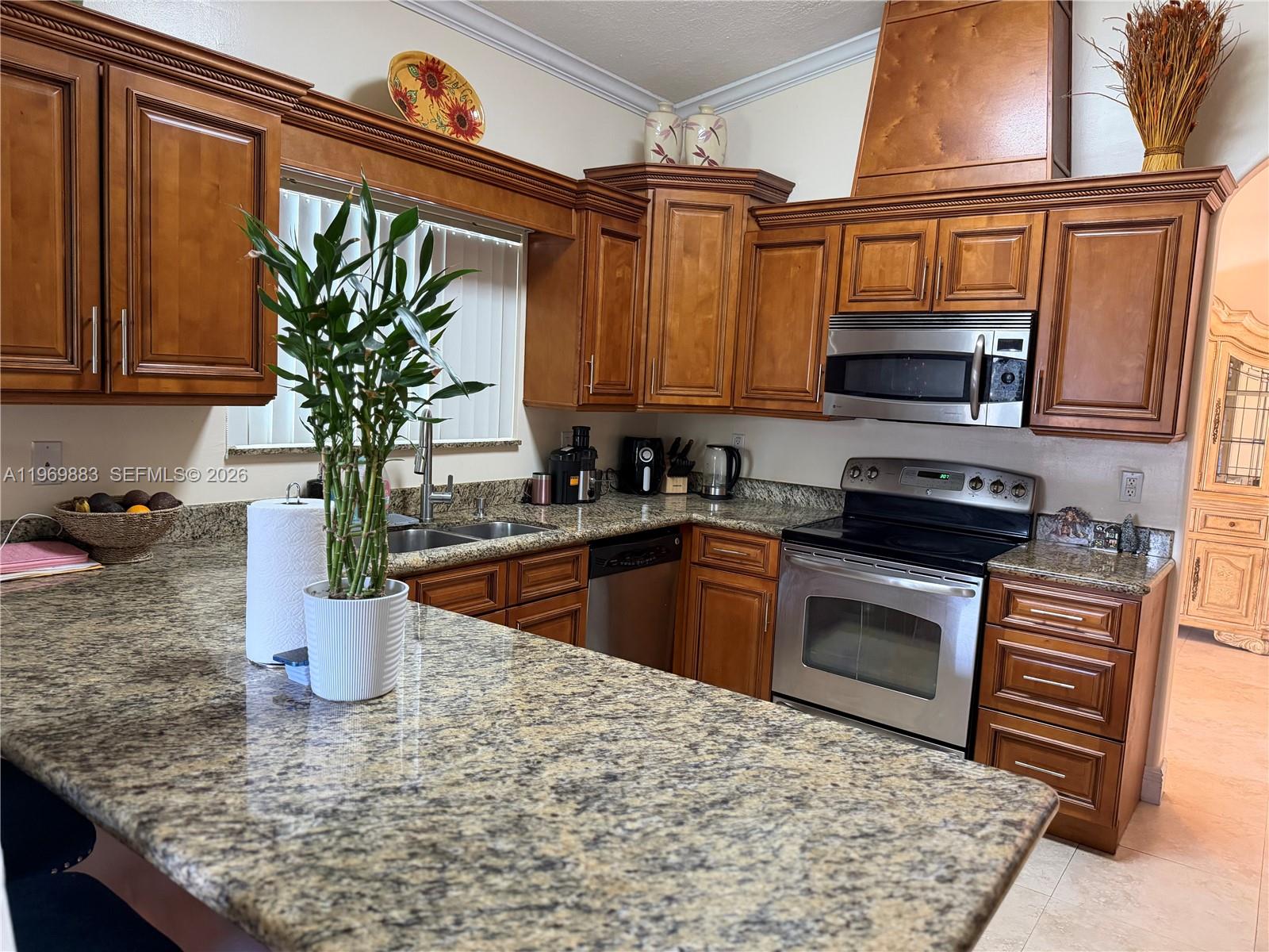 15641 Southwest 147th Avenue Miami, FL 33187 - Photo 8 of 20 a kitchen with stainless steel appliances granite countertop a sink stove and refrigerator