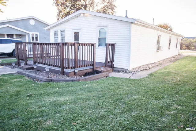a view of a white house with a yard and deck