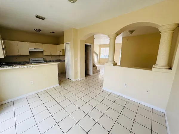 a view of a kitchen with kitchen island white cabinets and refrigerator
