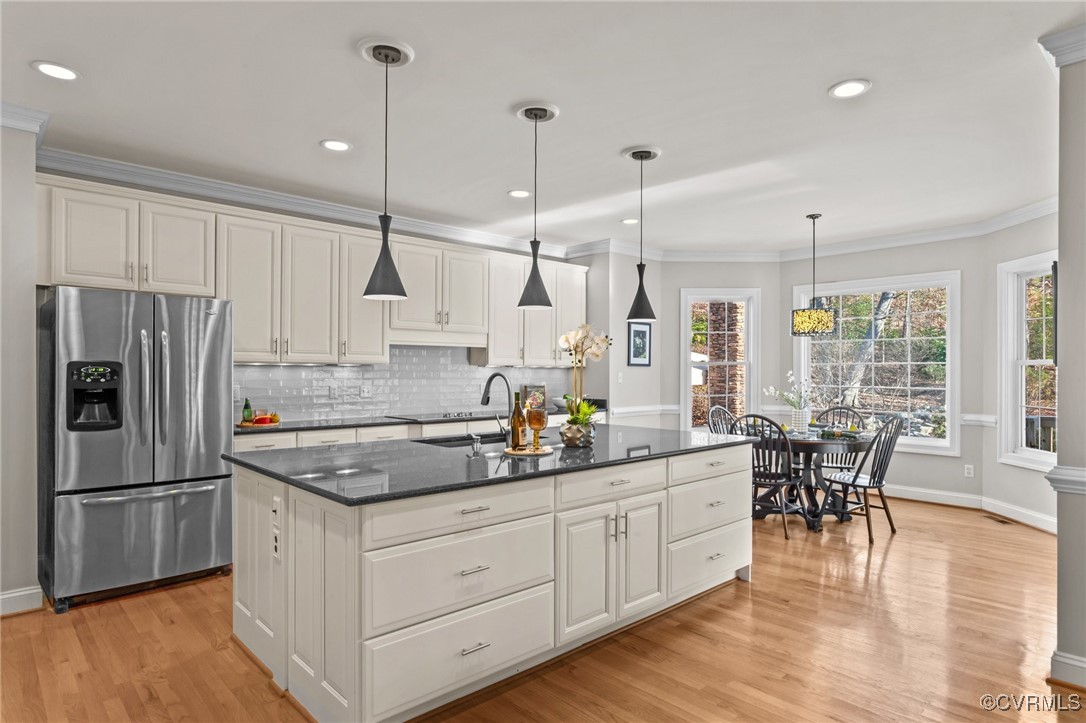 14337 Riverdowns S Drive Midlothian, VA 23113 - Photo 14 of 44 a kitchen with stainless steel appliances granite countertop a refrigerator a sink dishwasher a dining table and chairs with wooden floor