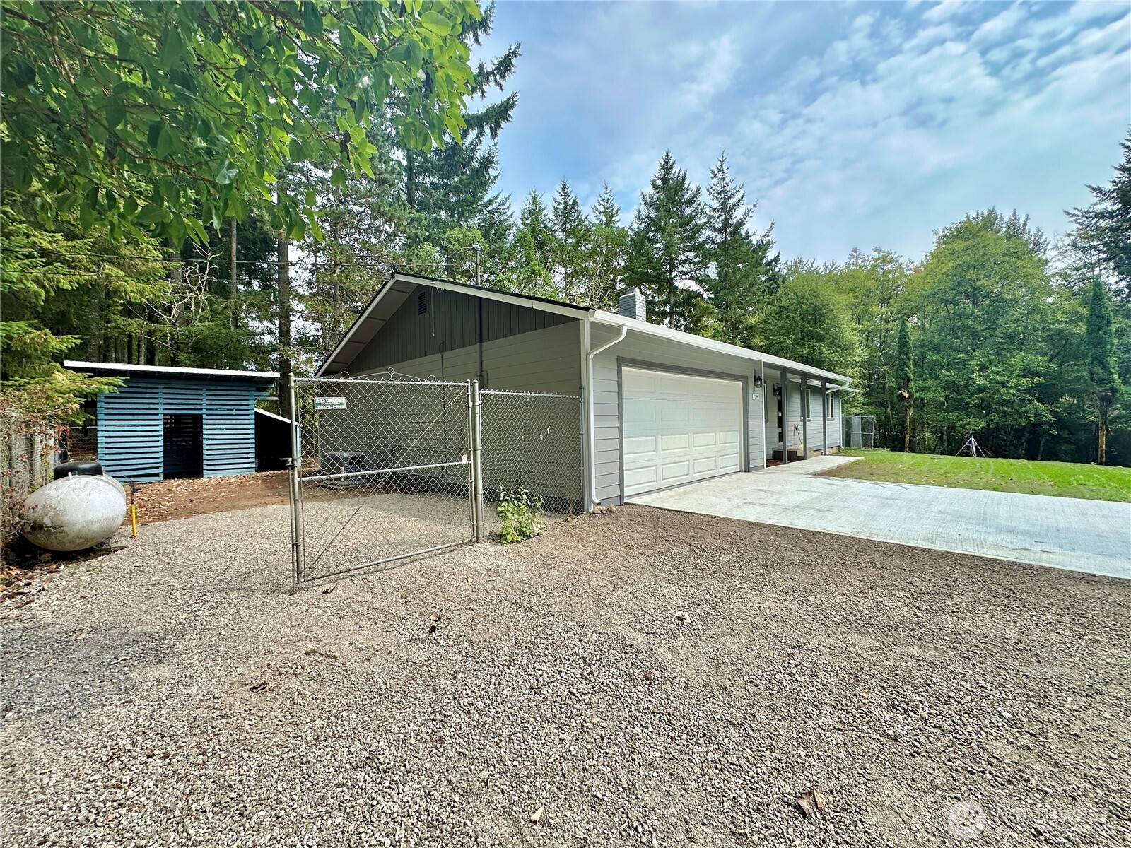 7044 Johnson Point Road Northeast Olympia, WA 98516 - Photo 24 of 36 a view of a house with a backyard and bushes
