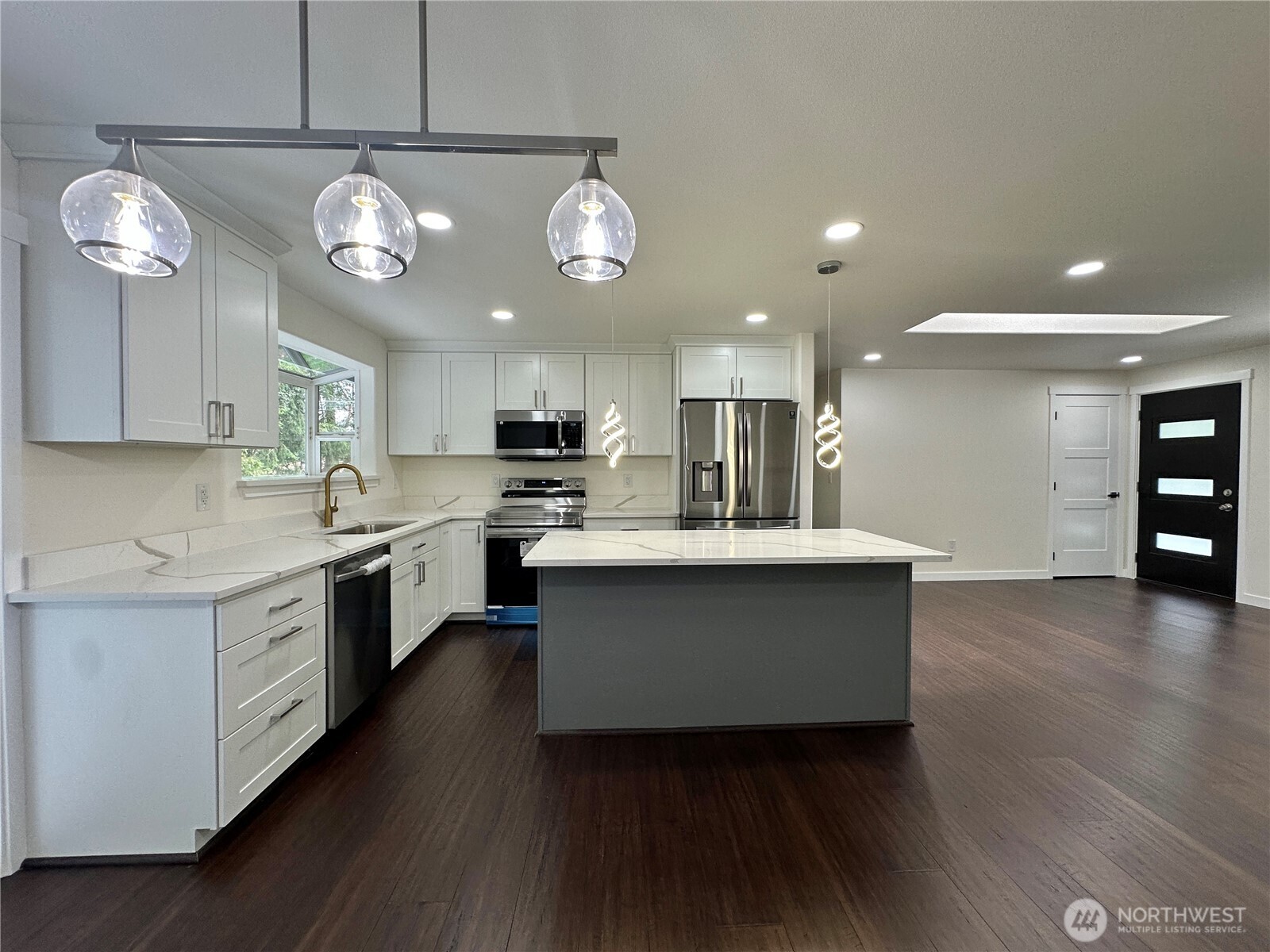 7044 Johnson Point Road Northeast Olympia, WA 98516 - Photo 3 of 36 a large kitchen with stainless steel appliances a large counter top a stove and a refrigerator