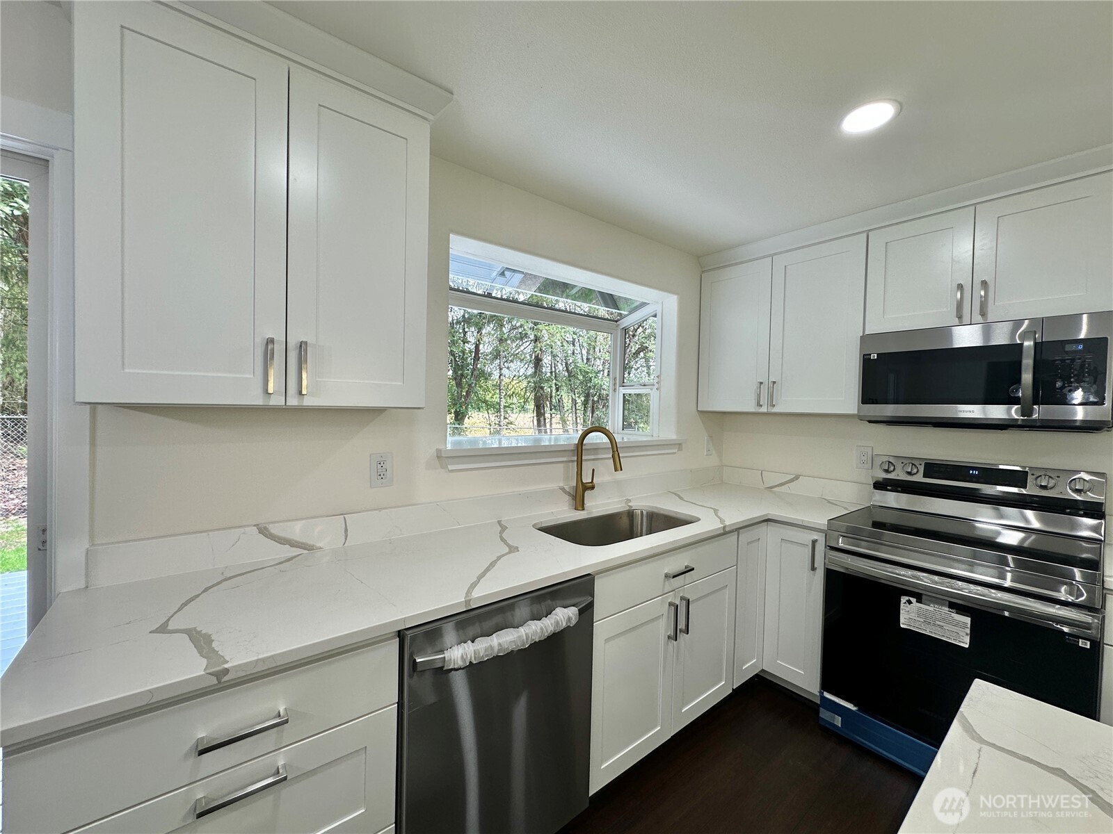7044 Johnson Point Road Northeast Olympia, WA 98516 - Photo 6 of 36 a kitchen with a sink stove top oven and cabinets