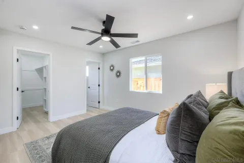 an empty room with a window and a ceiling fan