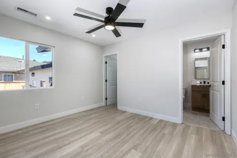 a living room with furniture couches and a dining table with wooden floor