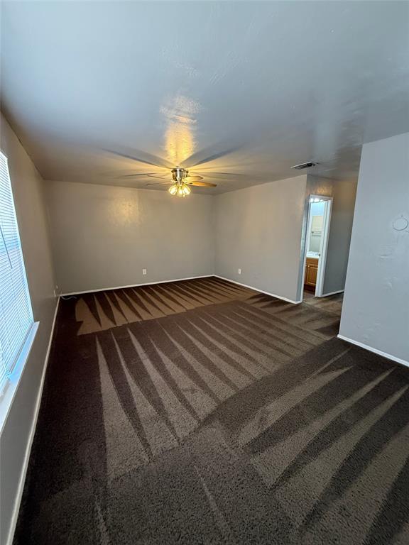 1714 Short Street, Unit D Cleburne, TX 76033 - Photo 2 of 9 Spacious room featuring broadloom carpeting, a ceiling fan with integrated lighting, and a window with horizontal blinds