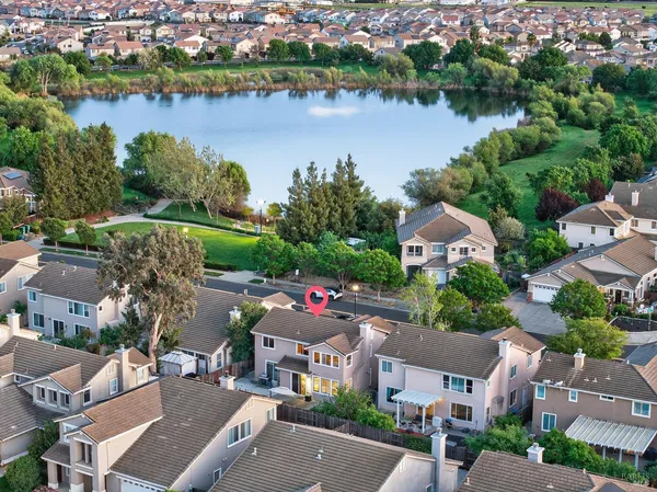 an aerial view of a city with lots of residential buildings ocean and mountain view in back