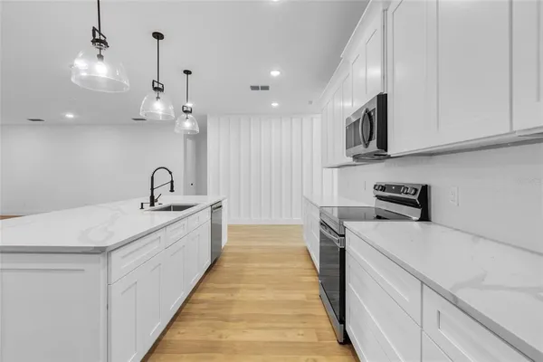 a kitchen with kitchen island a sink stainless steel appliances and cabinets