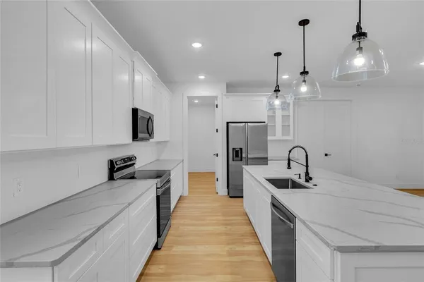 a kitchen with stainless steel appliances a sink stove and refrigerator