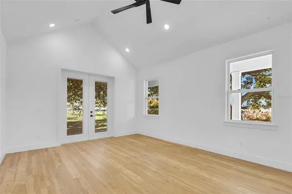 a view of an empty room with window and wooden floor