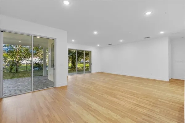 a view of an empty room with glass door and windows