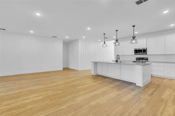 a view of kitchen with wooden floor and electronic appliances