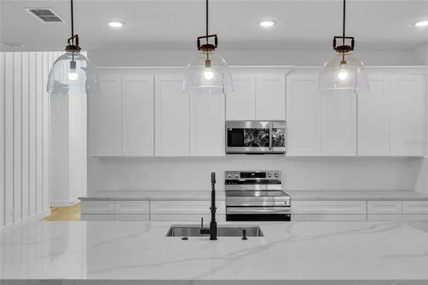 a kitchen with stainless steel appliances a stove a sink and cabinets