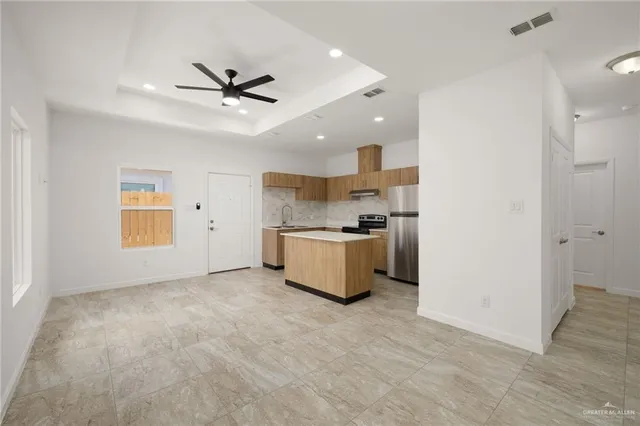 a view of a kitchen with a sink and a refrigerator