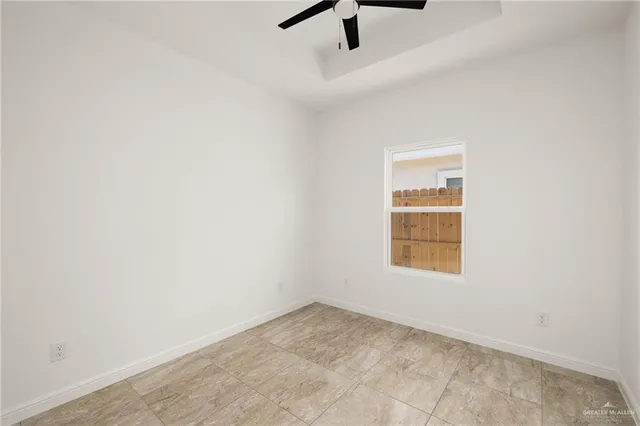 an empty room with a window and a fan