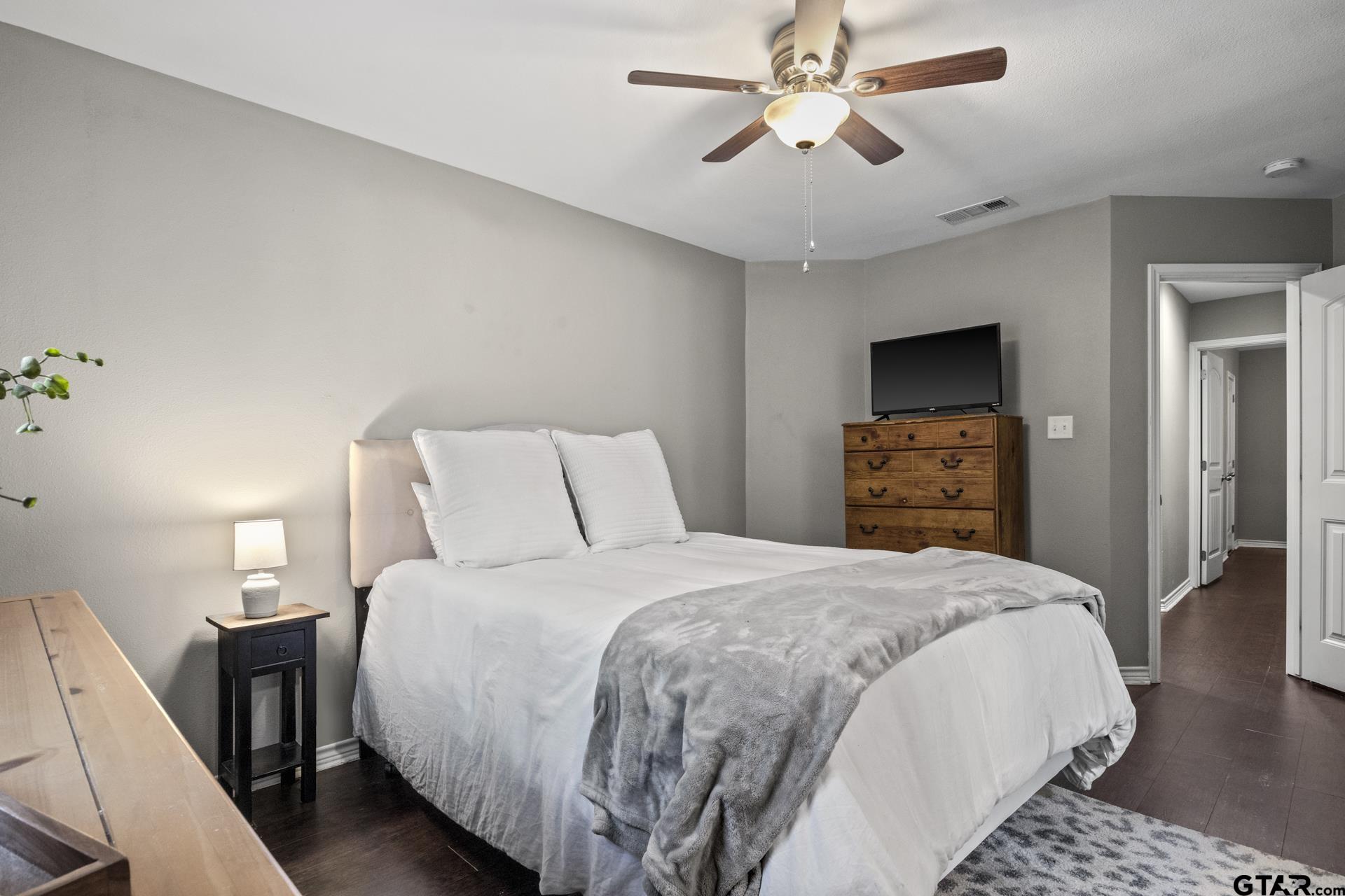 655 Daingerfield Street Pittsburg, TX 75686 - Photo 21 of 27 a bedroom with bed and wooden floor