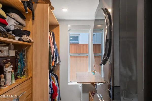 a view of walk in closet with clothes and shoes