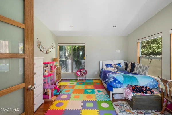 a living room with furniture and a baby crib