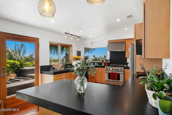 a kitchen with a table chairs stove and living room view