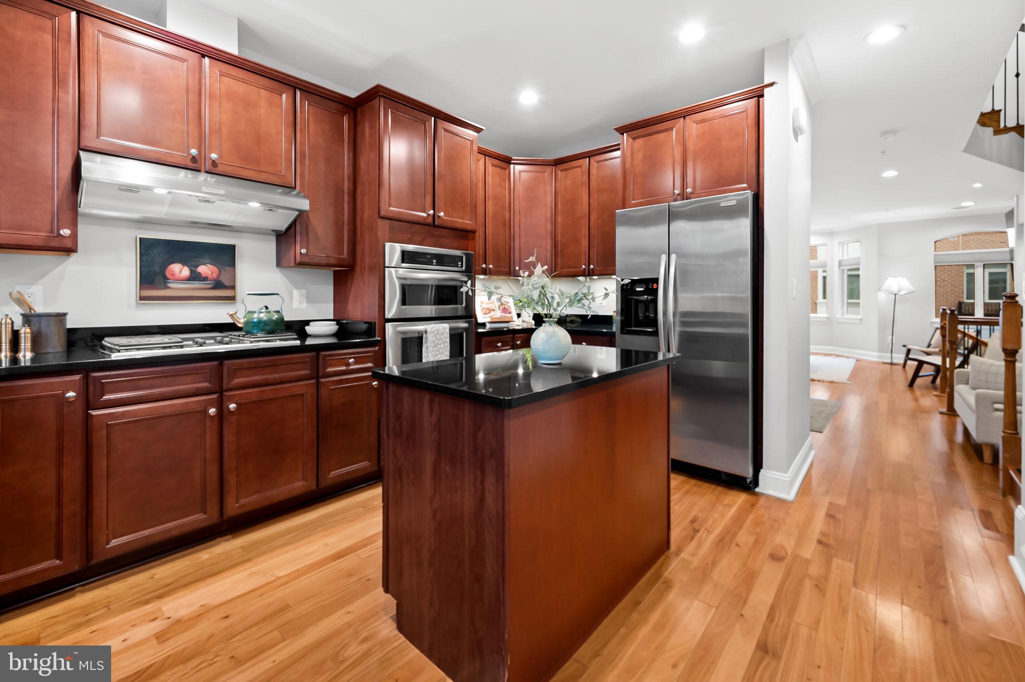 1024 Pier Pointe Landing, Unit 107 Baltimore, MD 21230 - Photo 16 of 51 a kitchen with kitchen island granite countertop wooden floors stainless steel appliances a sink and cabinets