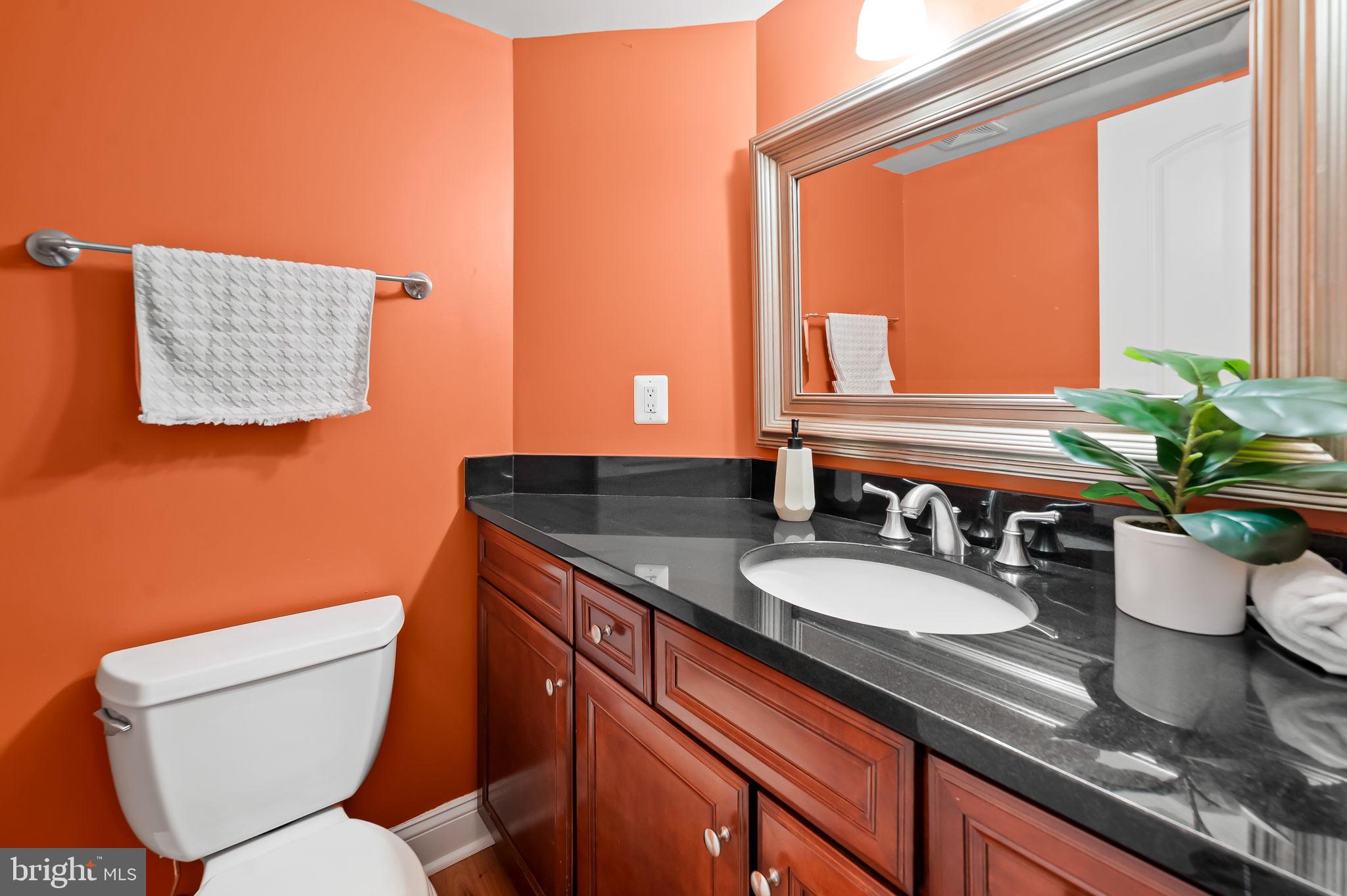 1024 Pier Pointe Landing, Unit 107 Baltimore, MD 21230 - Photo 18 of 51 a bathroom with a granite countertop toilet sink and mirror