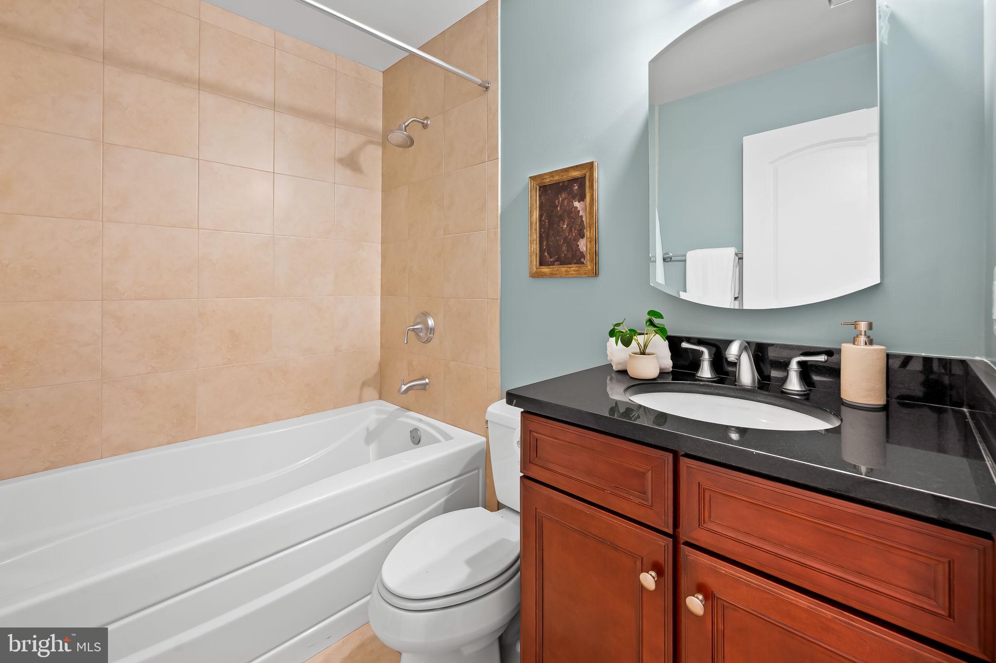 1024 Pier Pointe Landing, Unit 107 Baltimore, MD 21230 - Photo 28 of 51 a bathroom with a granite countertop sink mirror vanity and toilet
