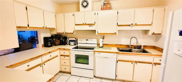 a kitchen with stainless steel appliances a sink a stove and white cabinets next to a window