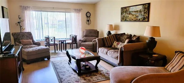 a living room with furniture a wooden floor and a large window