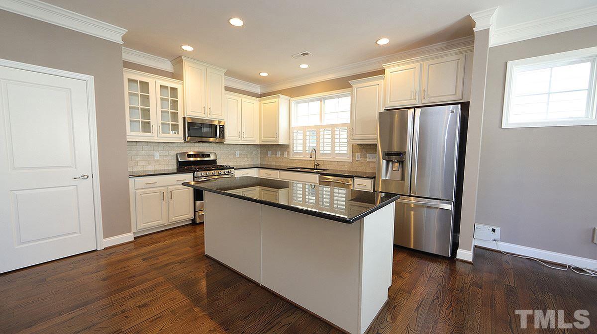 1541 Fullerton Place Raleigh, NC 27607 - Photo 7 of 29 a kitchen with stainless steel appliances granite countertop a refrigerator a sink a stove and white cabinets with wooden floor