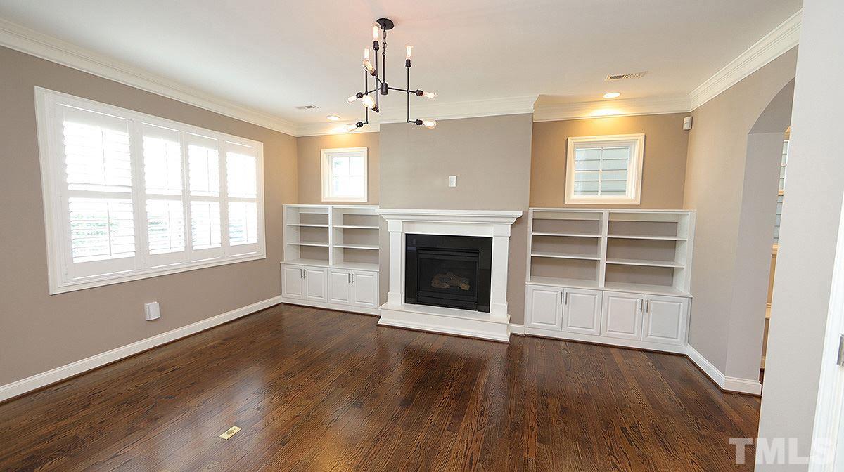 1541 Fullerton Place Raleigh, NC 27607 - Photo 9 of 29 an empty room with wooden floor a ceiling fan and windows