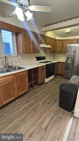 a large kitchen with stainless steel appliances wooden floors and wooden cabinets