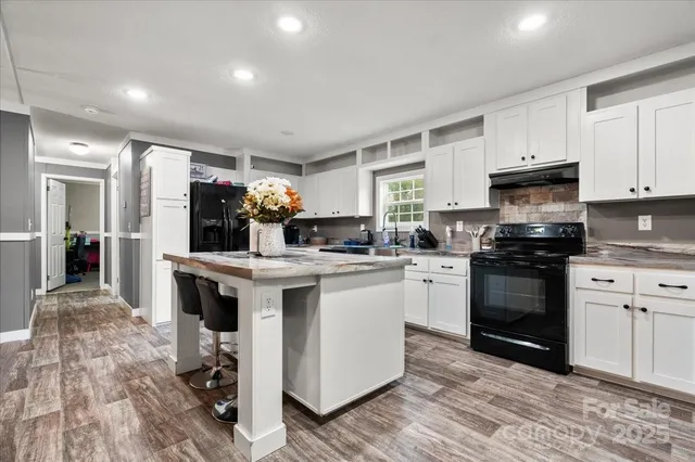 a kitchen with granite countertop a stove top oven and cabinets