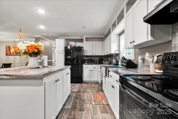 a kitchen with stainless steel appliances granite countertop a sink stove and cabinets